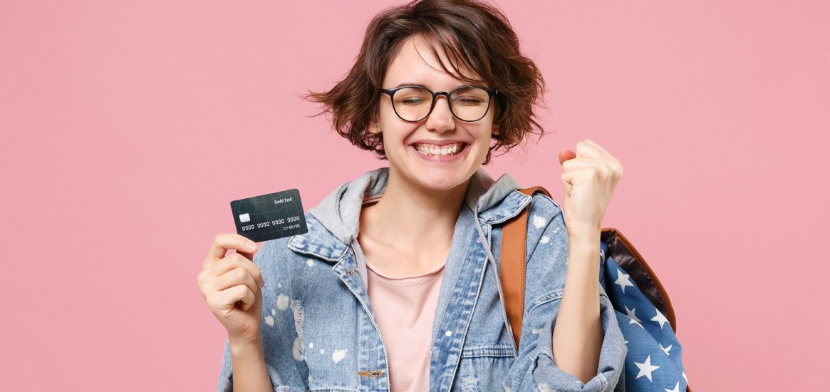 Young woman excited while holding credit card.